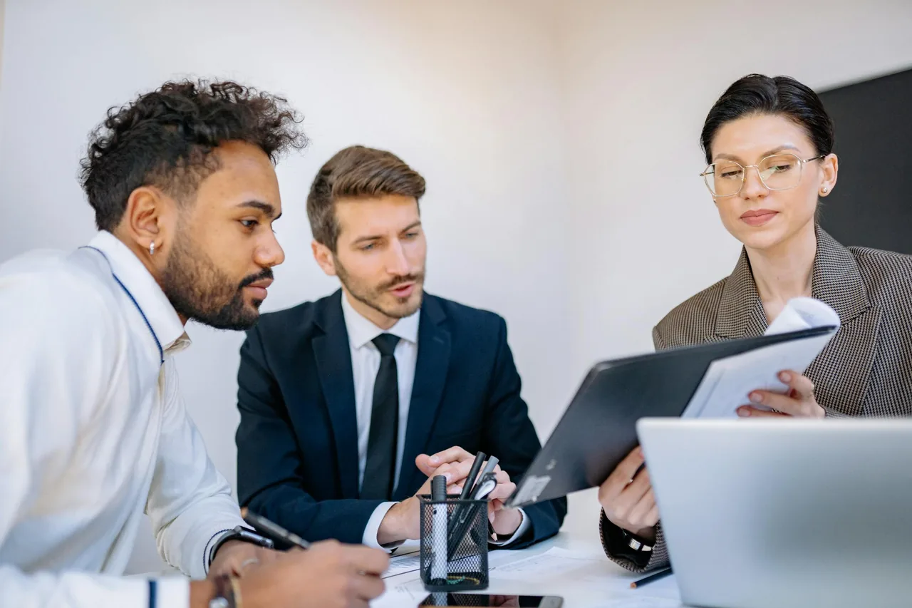 Professionals reviewing documents during a recruitment meeting