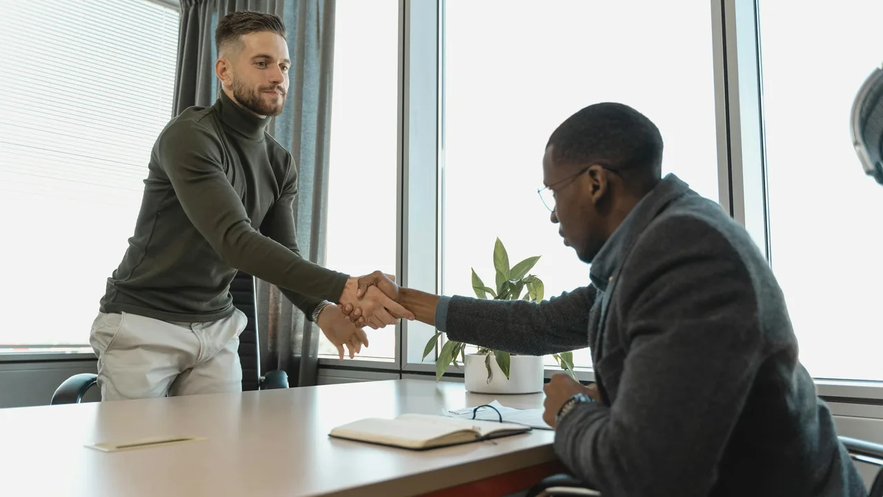 Two professionals shaking hands in a meeting room